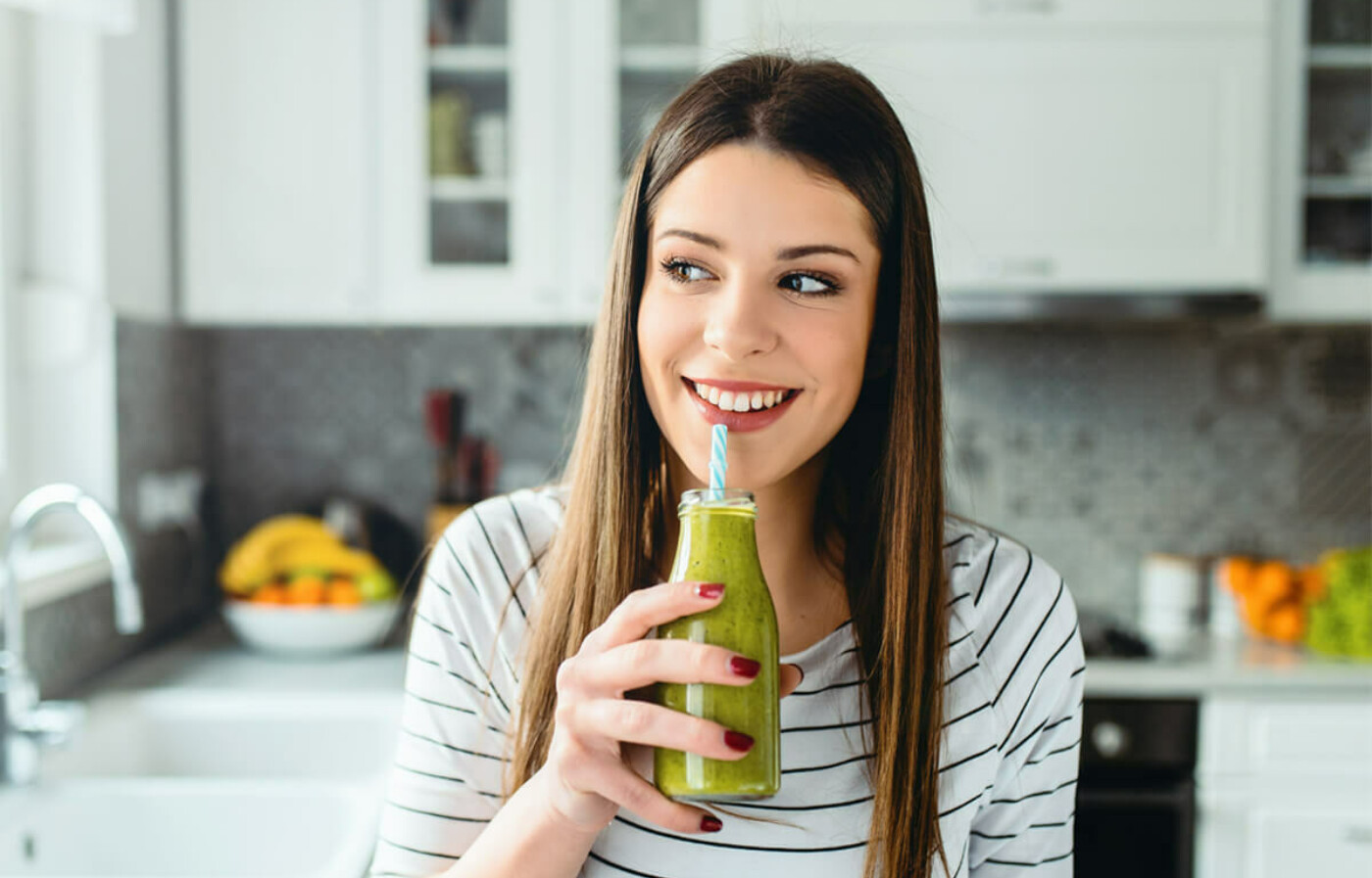 woman in kitchen with smoothie