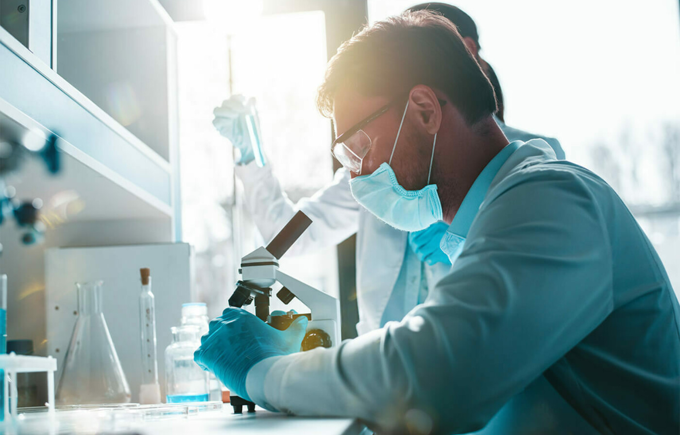 woman in lab looking in microscope