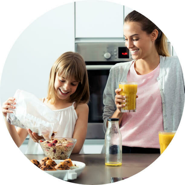 woman and daughter snacking in kitchen