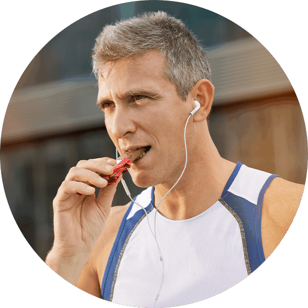 older man eating granola bar
